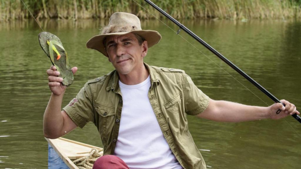 Fritz sitzt im Kanu und hat einen Flip-Flop an der Angel.