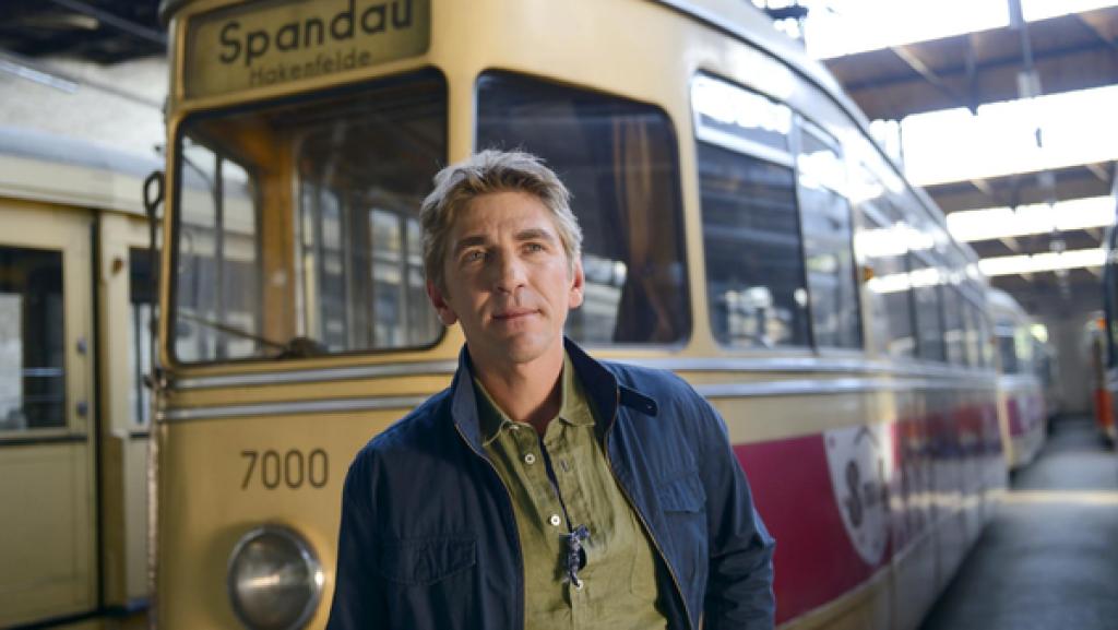 Eine rote Straßenbahn fährt durch die Stadt.