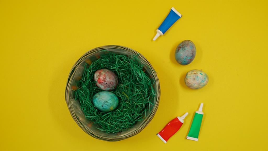 Eier mit Rasierschaum färben | Rechte: KiKA Mit Rasierschaum gefärbte Eier liegen in einem Osternet, daneben Lebensmittelfarbe in verschiedenen Farben