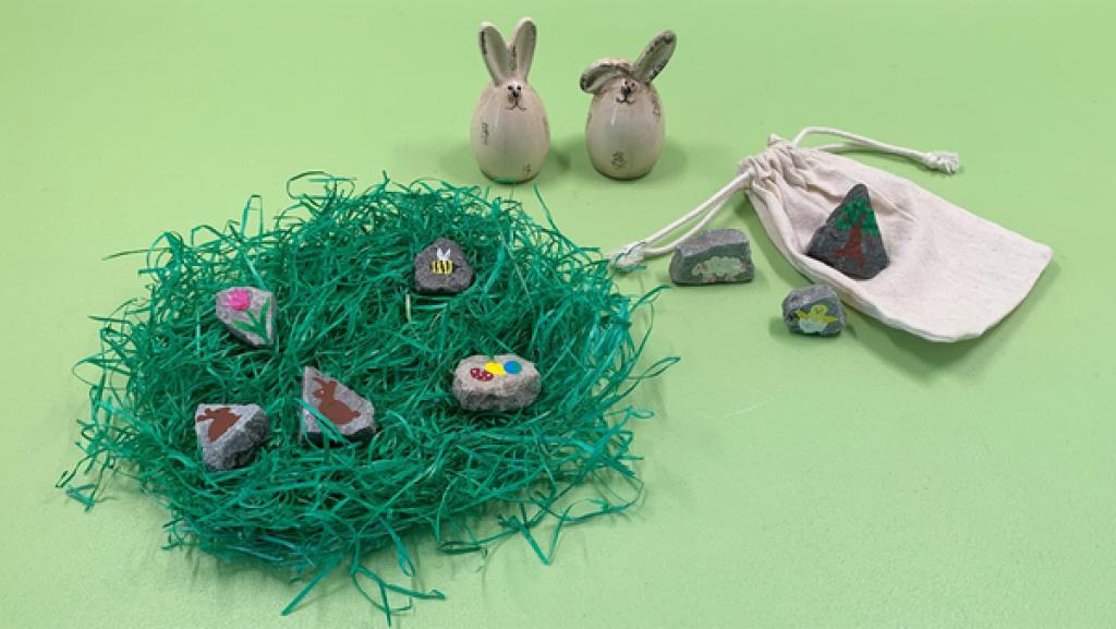 Steine-Spiel | Rechte: KiKA bemalte Steine in einem Osternest, daneben zwei Hasen aus Porzellan