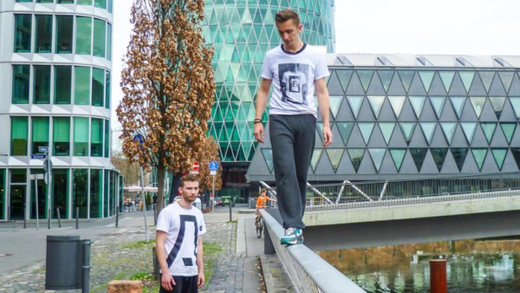 Eric macht Parkour und balanciert auf Geländer