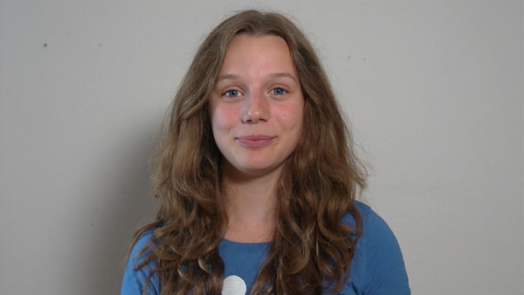 Rechte: rbb/Matthias Eder Ein Porträt von Clara vor einem hellgrauen Hintergrund. Sie schaut lächelnd in die Kamera.