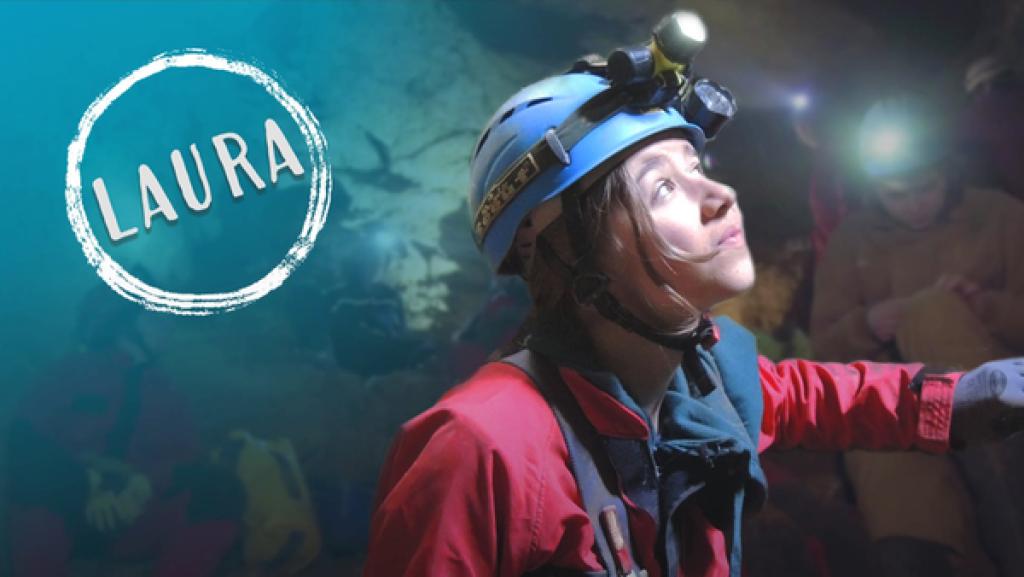 Mädchen in einer Höhle mit Stirntaschenlampe