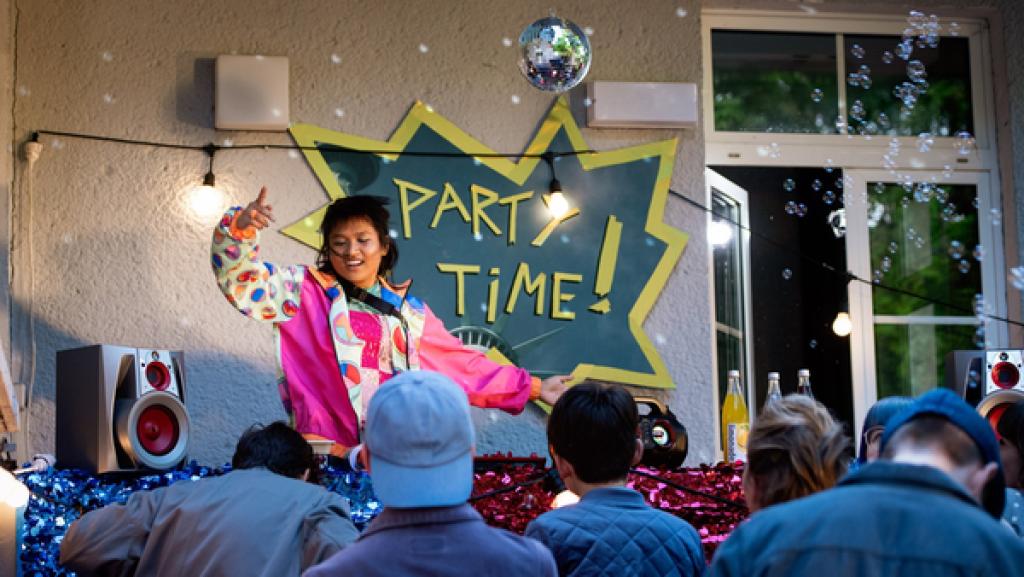 Schloss Einstein (Party am Einstein) | Rechte: Kika Eine Jugendliche tanzt auf einer Bühne vor Zuschauern. Hinter ihr steht an der Wand „PARTY TIME!“.