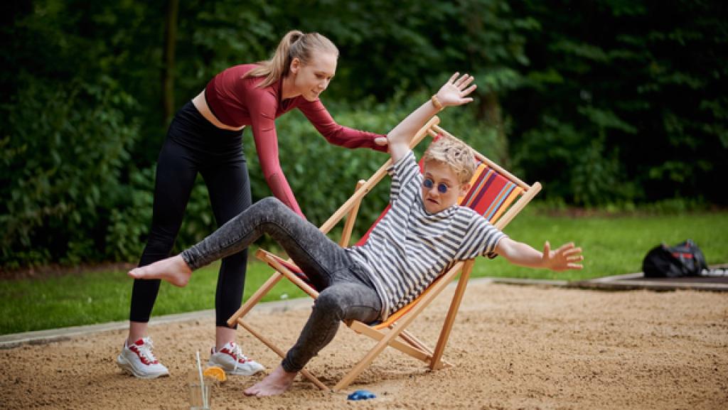 Schloss Einstein (1011) | Rechte: Kika Ein Mädchen hält eine umkippenden Ligestuhl, auf dem ein Junge die Arme hochreißt.