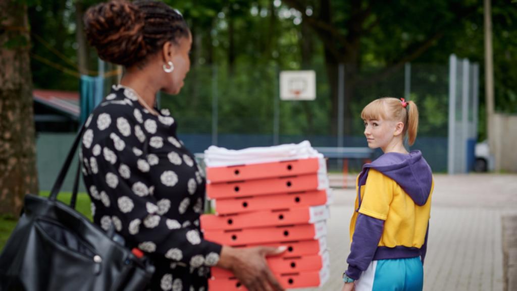 Schloss Einstein (1010) | Rechte: Kika Ein Mädchen dreht sich zu einer Frau um, die mehrere Pizzakatons auf dem Arm trägt.