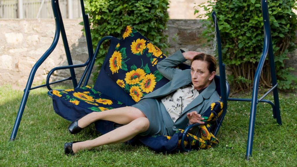 Ältere Frau auf kaputter Hollywoodschaukel