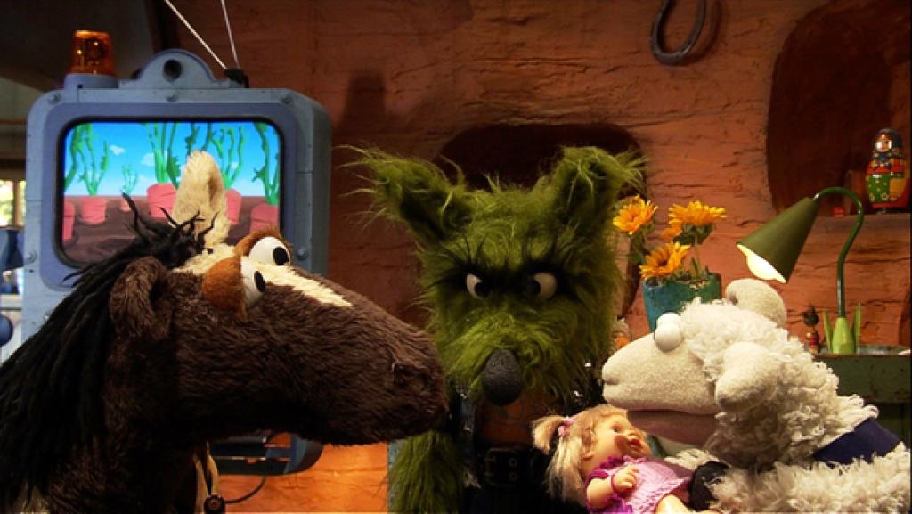 Pferd, Wolf und Wolle schauen auf eine Puppe