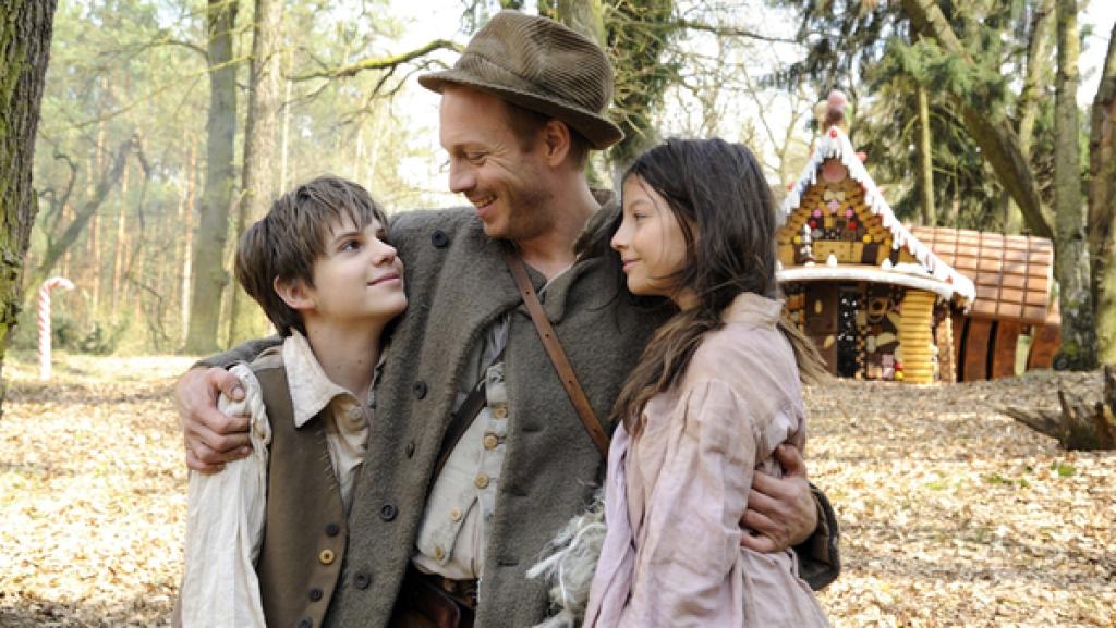 Der Vater (Johann von Bülow) hat seine Kinder Hänsel (Friedrich Heine) und Gretel (Mila Böhning) im Wald wieder gefunden.