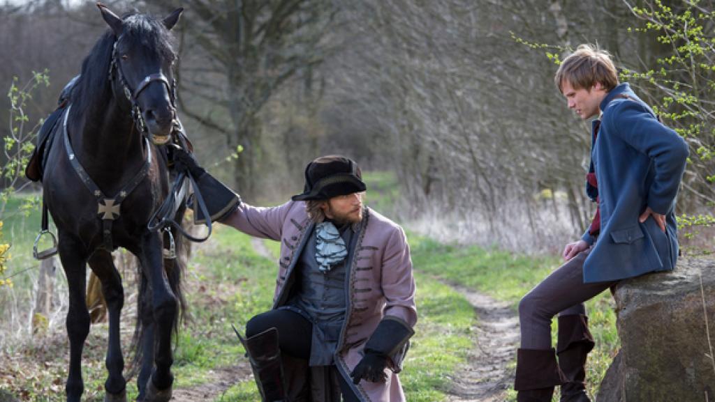 Hans im Glück | Rechte: NDR/Georges Pauly Ein Junker (Sebastian Ströbel) begutachtet den riesigen Goldklumpen, den Hans (Anton Spieker) mit sich trägt - und schlägt den ersten Tausch vor.