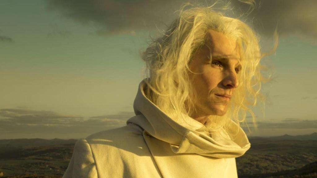 Rübezahls Schatz | Rechte: ZDF/Conny Klein "Rübezahls Schatz": Im Hintergrund eine sich bis zum Horizont erstreckende Waldlandschaft. Im Vordergrund Rübezahl (Sabin Tambrea). Er hat langes, blondes, im Wind wehendes Haar und trägt einen weißen Mantel mit breiten Kragen. Ernst schaut er ins Sonnenlicht.