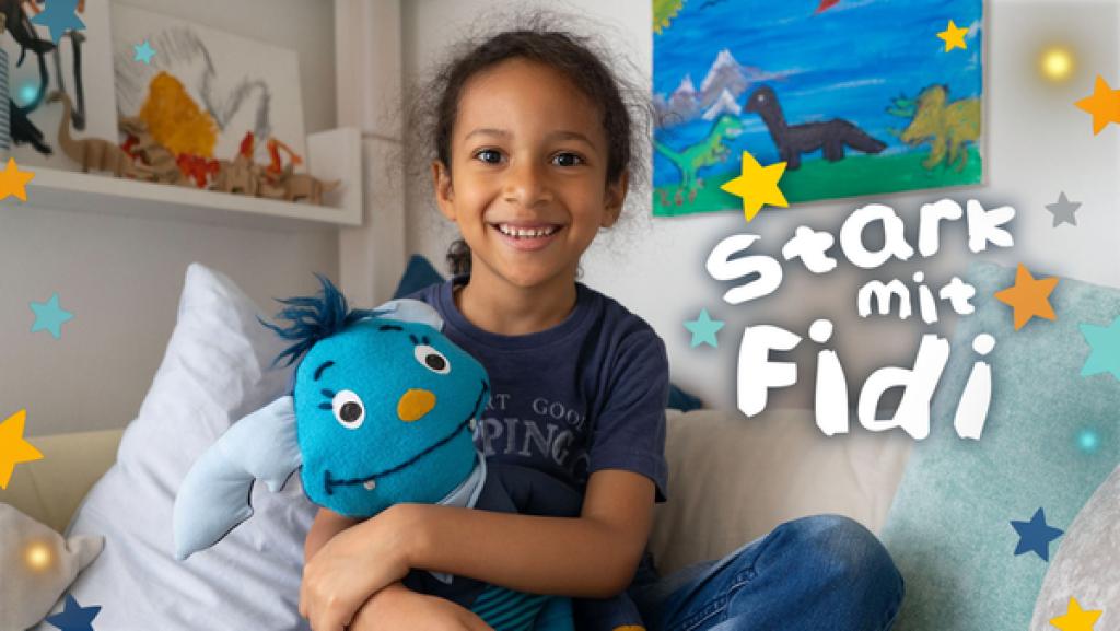 Ein Junge mit einer blauen Kuschelfledermaus in der Hand 