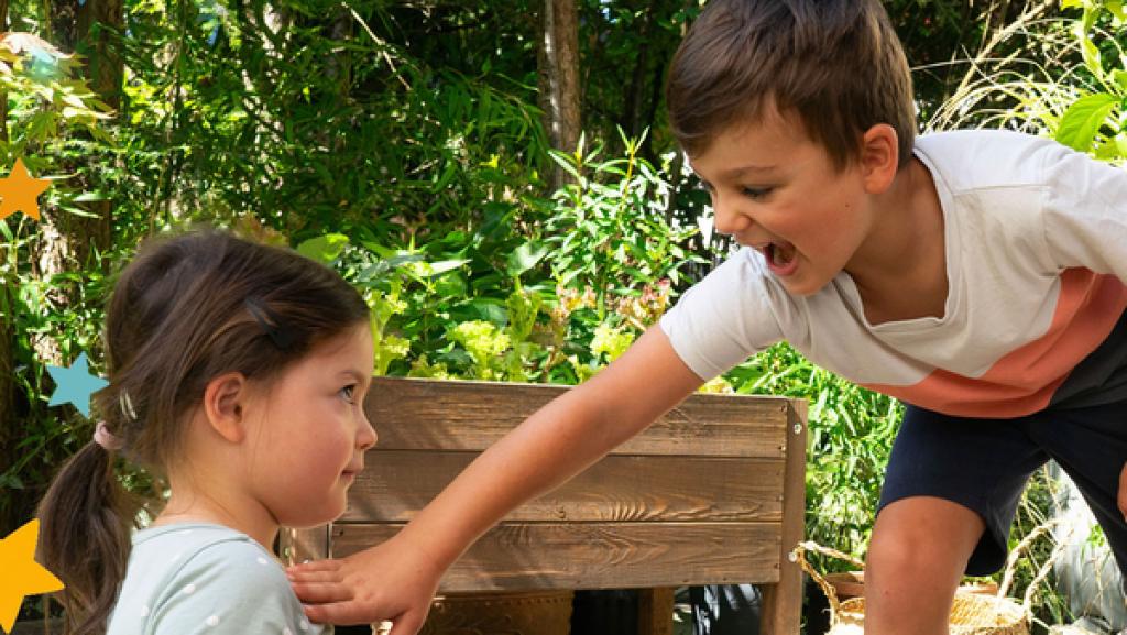 Alex und seine Schwester im Garten mit Bauklötzen. Alex stößt seine Schwester.