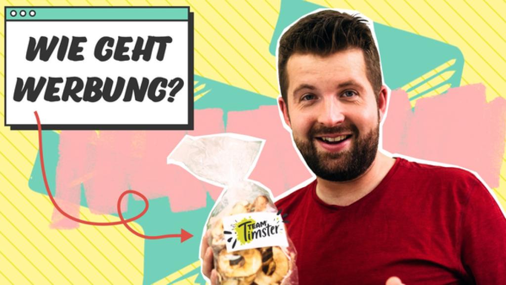 Rechts hält Tim eine Tüte Gebäck mit einem Team Timster-Etikett vor sich und lächelt. Links oben die Frage "Wie geht Werbung?".