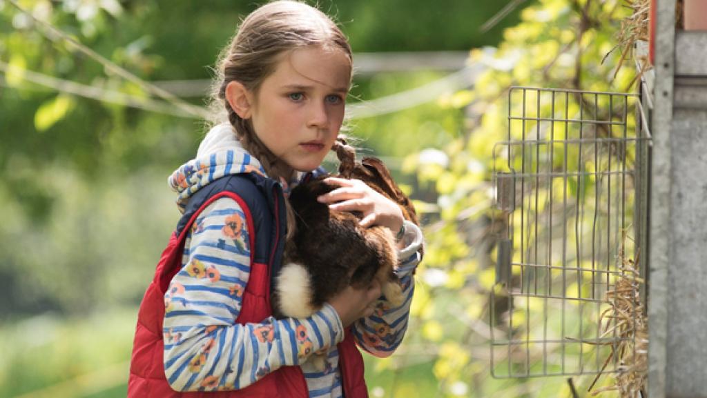 Lucy aus der Serie "Tiere bis unters Dach" mit einem Kanichen auf dem Arm
