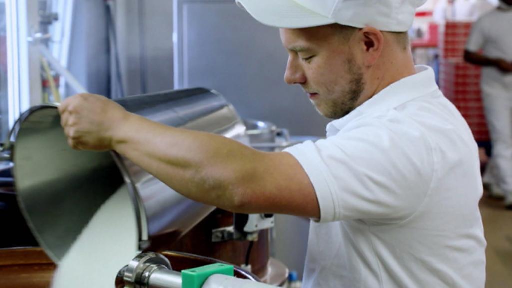 Koch füllt Zucker in einen großen Topf