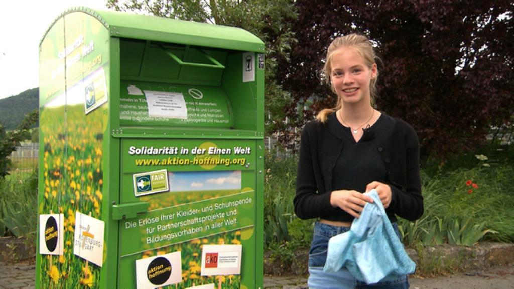 Tigerenten-Reporterin Juli vor einem Altkleidercontainer
