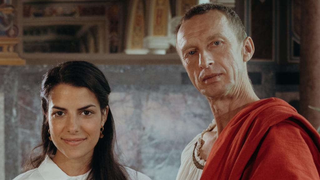 Rechte: KiKA/Sabine Finger Cäsar (Thorsten Krohn) und Clarissa stehen nebeneinander, Clarissa hält die Zeitmaschine in der Hand.