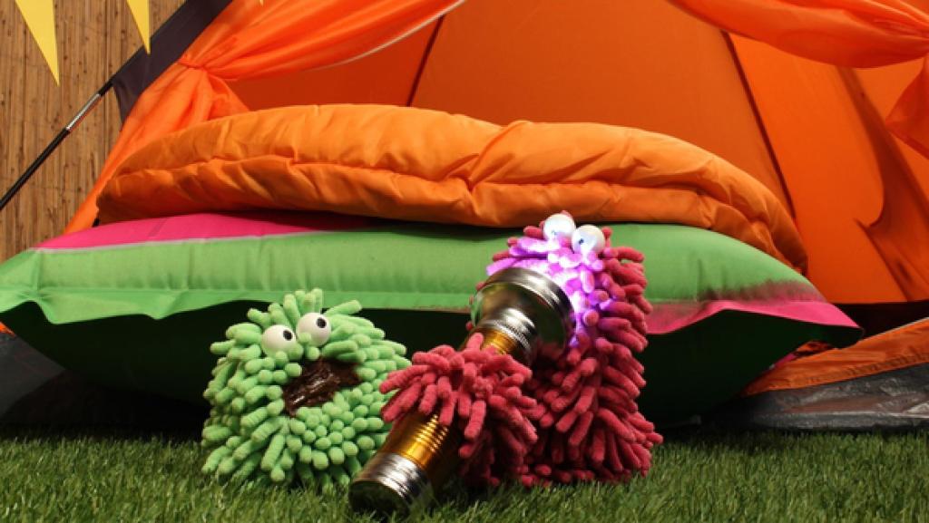 Wisch und Mop sitzen mit einer Taschenlampe vor dem Zelt