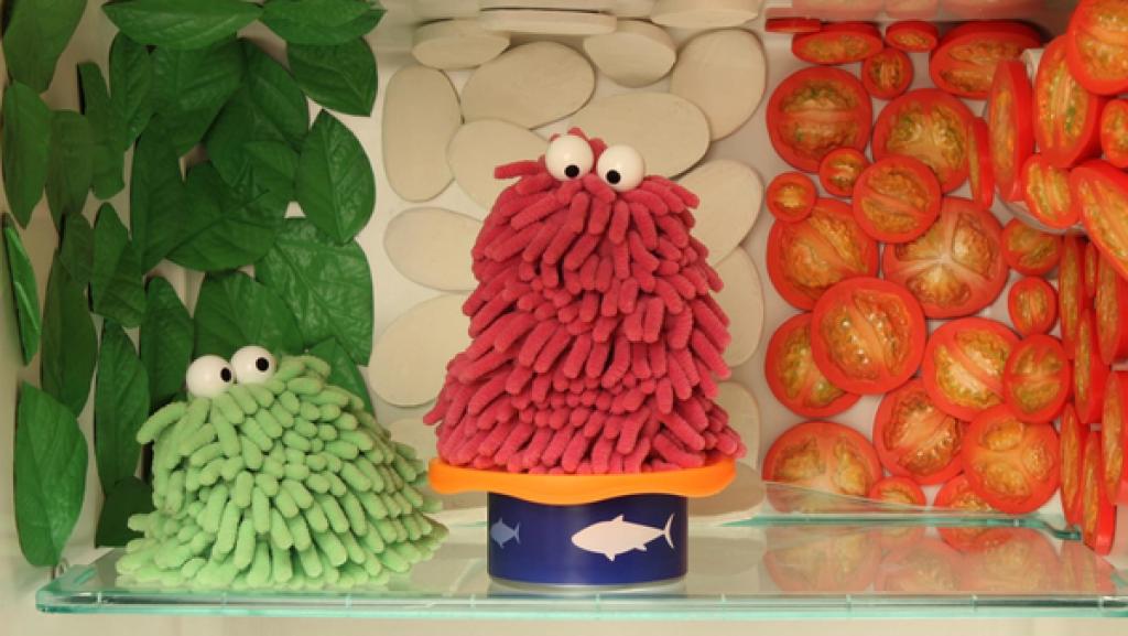 Wisch und Mop sitzen im Kühlschrank, der mit Lebensmitteln tapeziert ist